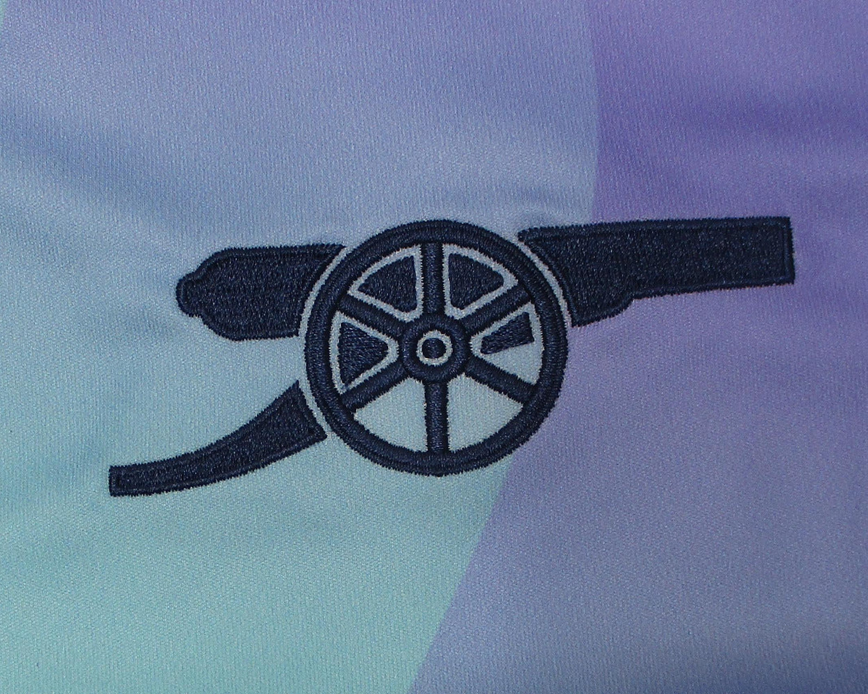 Arsenal London Third Trikot 2024/25 Adidas Herren mit eingesticktem Vereinswappen, Adidas Logo und Aeroready Technologie. Detailansicht Vereinswappen Arsenal.