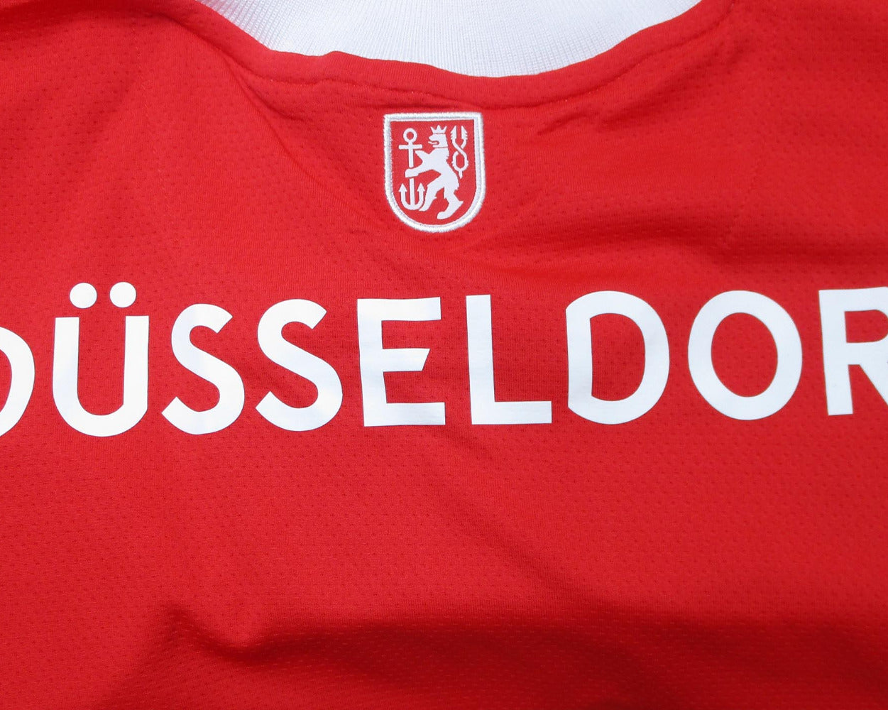 Rotes offizielles Fortuna Düsseldorf Heimtrikot 2020/21 von Uhlsport in Herrengröße. Detailansicht Nacken.
