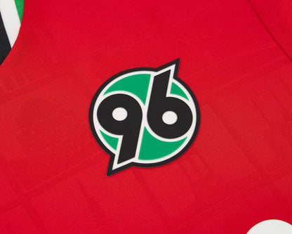 Hannover 96 Kinder Trikot Home 2026  2027 Macron Herren rot geprägte Wahrzeichen Eco Softlock neu mit Etikett. Detailansicht Vereinswappen.