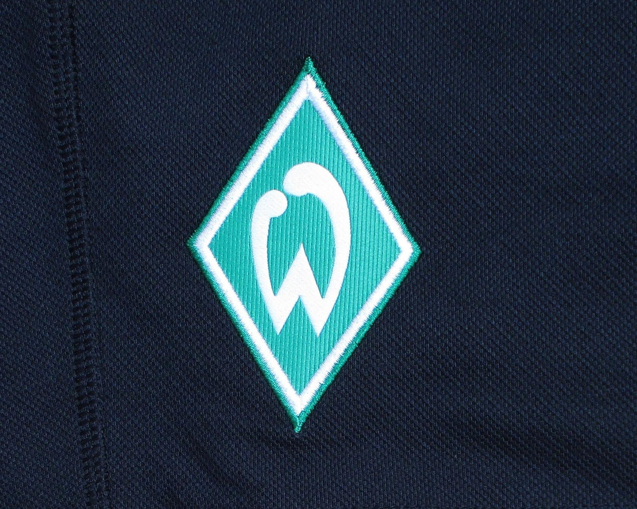 Schwarze SV Werder Bremen Trainingsshorts aus der Travel-Kollektion 2020/21 von Umbro in Übergröße mit aufgesticktem Vereinswappen – Detailansicht Wappen.