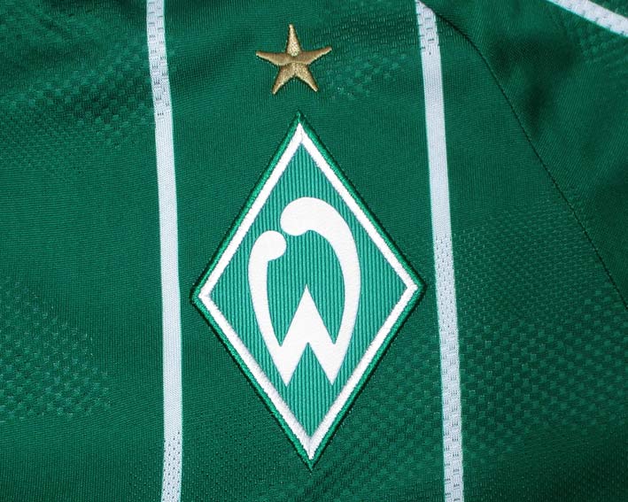 SV Werder Bremen Trikot Home 2025/26 von Hummel. Offizielles Fußballtrikot in Herrengröße. Detailansicht Wappen.