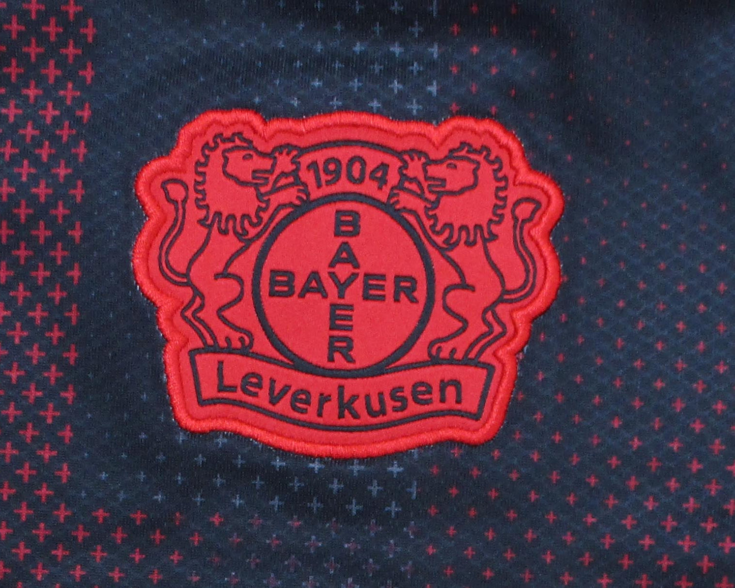 Offizielles New Balance TSV Bayer 04 Leverkusen Heimtrikot der Saison 2025/26 für Herren in Schwarz und Rot mit gesticktem Vereinswappen – Neu mit Etikett. Vereinswappen Details.